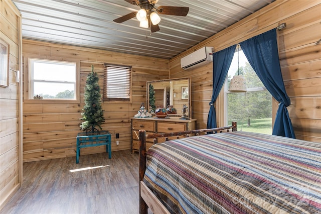 bedroom featuring hardwood / wood-style floors, ceiling fan, a wall mounted air conditioner, and multiple windows