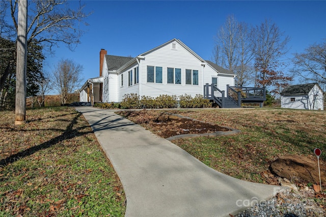 view of property exterior featuring a deck and a yard