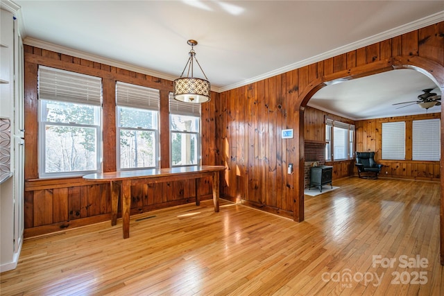 dining space with ceiling fan, light wood-type flooring, a healthy amount of sunlight, and crown molding