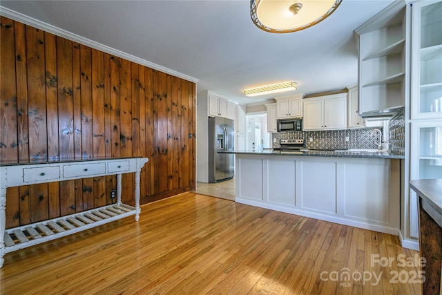 kitchen featuring stainless steel appliances, white cabinetry, light wood-type flooring, tasteful backsplash, and stone countertops