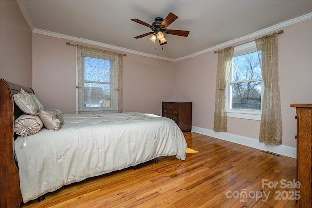 bedroom with ceiling fan, hardwood / wood-style floors, and crown molding