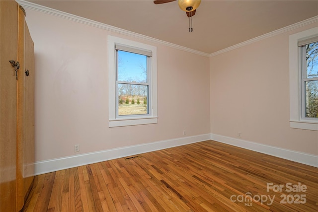 empty room with ornamental molding and hardwood / wood-style flooring