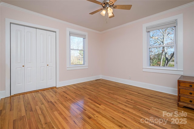 unfurnished bedroom with crown molding, ceiling fan, light hardwood / wood-style flooring, and a closet