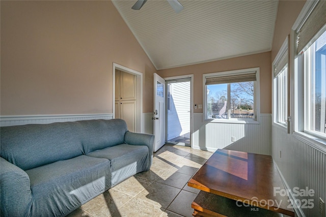 living room featuring lofted ceiling, ceiling fan, and light tile patterned floors