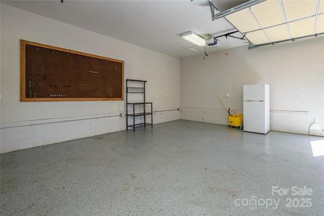 garage with white refrigerator and a garage door opener