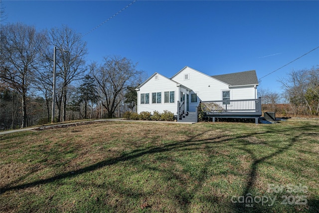 rear view of property featuring a lawn and a wooden deck