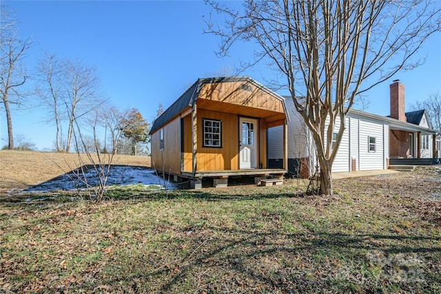 rear view of house with a lawn and an outbuilding