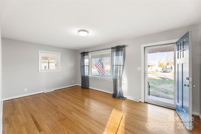 empty room with plenty of natural light and light wood-type flooring