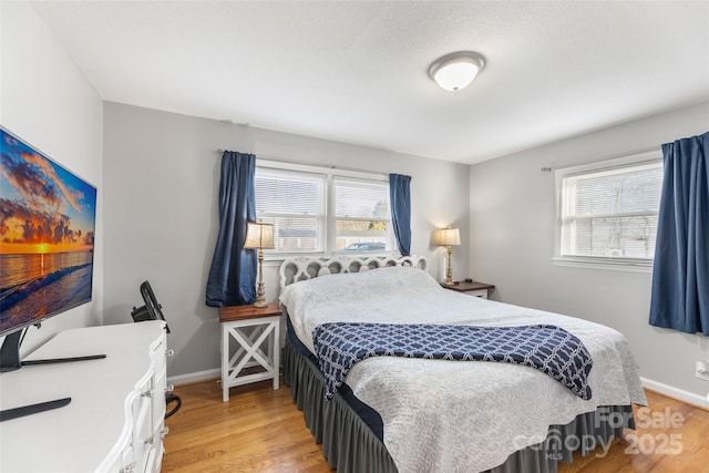 bedroom with light hardwood / wood-style flooring and multiple windows