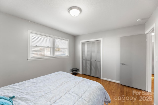 bedroom with a closet and light hardwood / wood-style floors