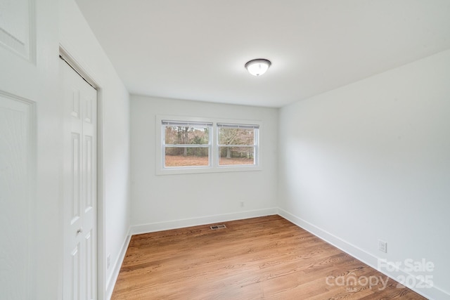 unfurnished bedroom featuring light hardwood / wood-style flooring and a closet