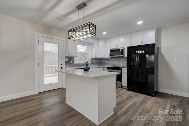 kitchen with stainless steel appliances, white cabinetry, a center island, hanging light fixtures, and dark wood-type flooring