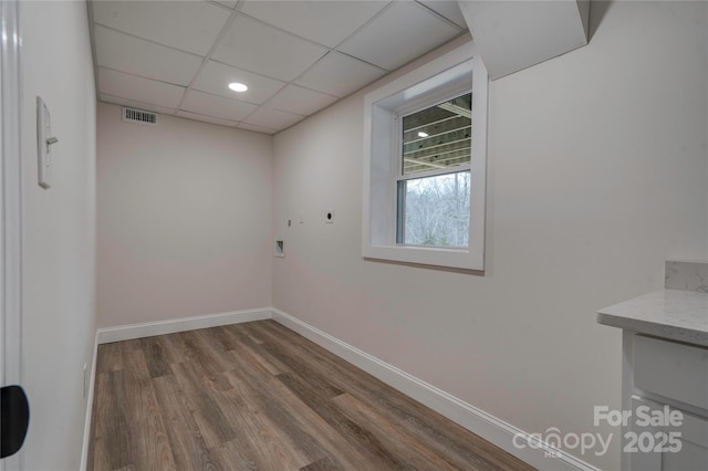 empty room featuring hardwood / wood-style flooring and a paneled ceiling