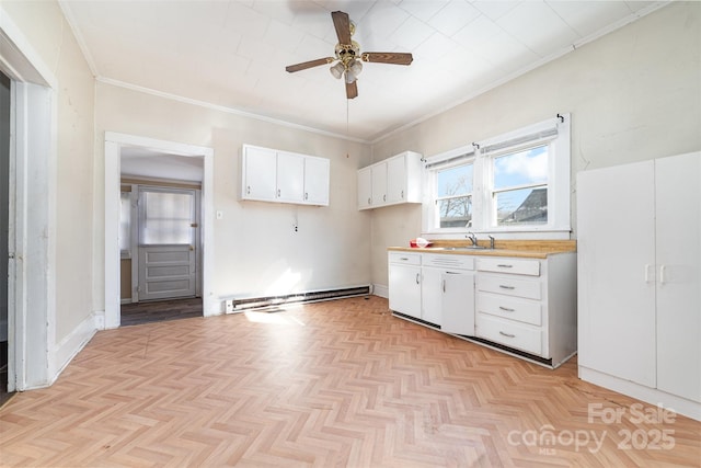 kitchen with light parquet flooring, ceiling fan, a baseboard heating unit, white cabinets, and sink