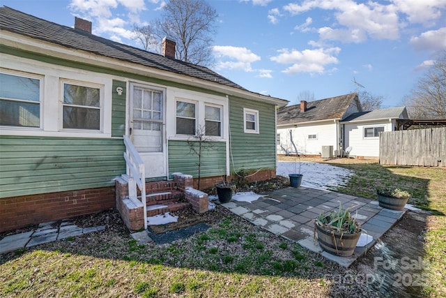 rear view of house with central AC unit and a patio