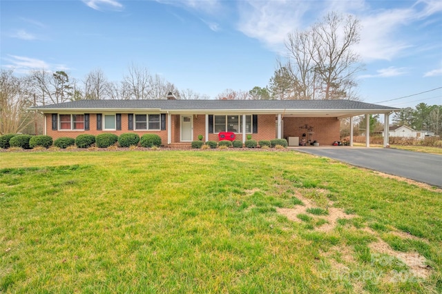 single story home with aphalt driveway, an attached carport, brick siding, and a front lawn