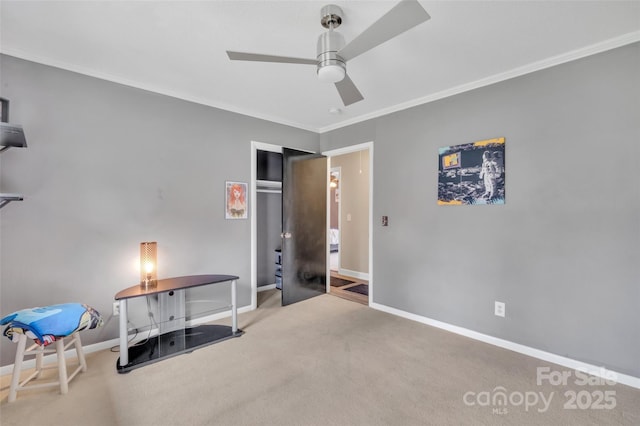 miscellaneous room with baseboards, carpet floors, ceiling fan, and ornamental molding