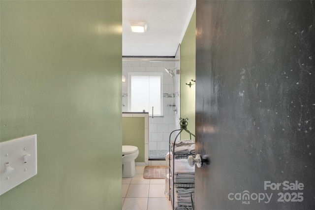 bathroom featuring tile patterned flooring, toilet, and walk in shower