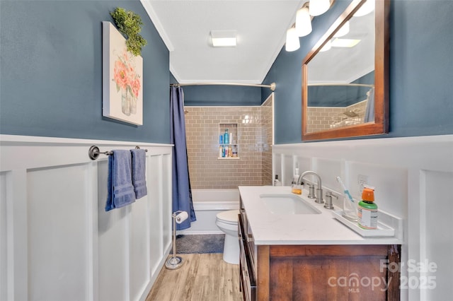 bathroom featuring toilet, ornamental molding, shower / bath combo, wood finished floors, and vanity