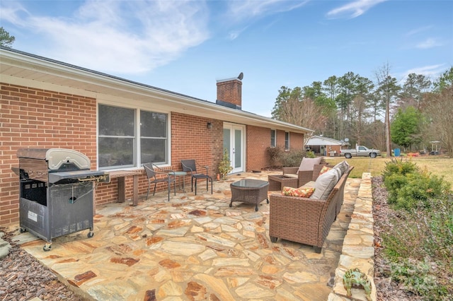 view of patio with an outdoor living space, french doors, and grilling area