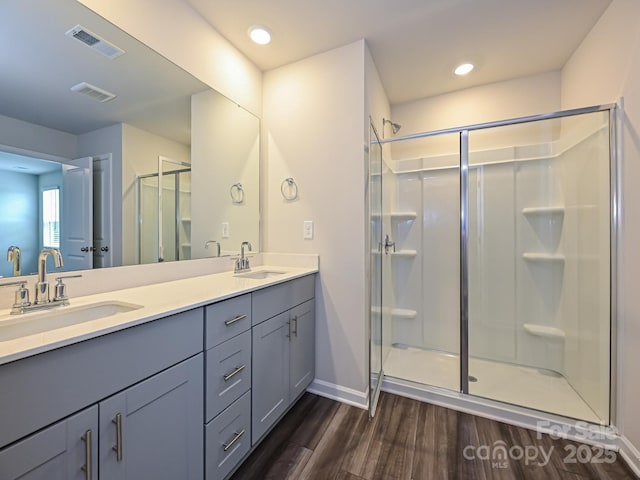 bathroom with a shower with door, vanity, and hardwood / wood-style flooring