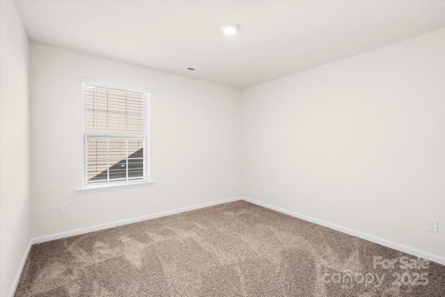 empty room with a wealth of natural light and carpet flooring