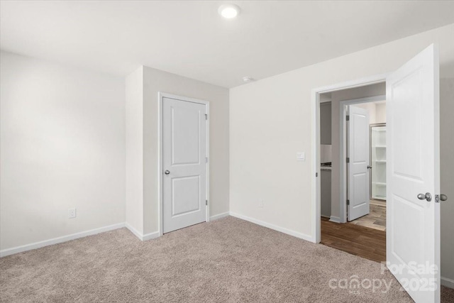 unfurnished bedroom featuring a closet and light carpet