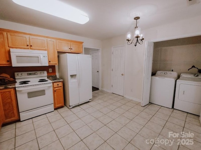 kitchen featuring white appliances, hanging light fixtures, washing machine and dryer, light tile patterned floors, and an inviting chandelier