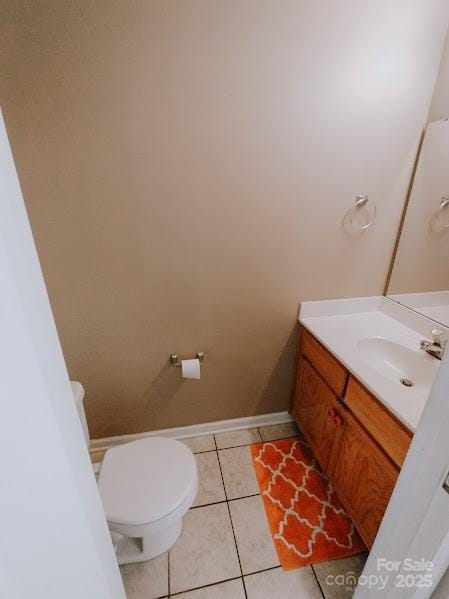 bathroom with toilet, tile patterned flooring, and vanity