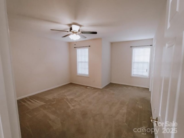 carpeted spare room with ceiling fan and a healthy amount of sunlight