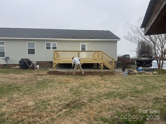 back of property with a lawn and a deck