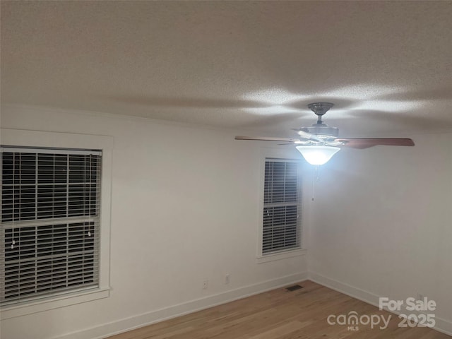 unfurnished room with hardwood / wood-style floors and a textured ceiling