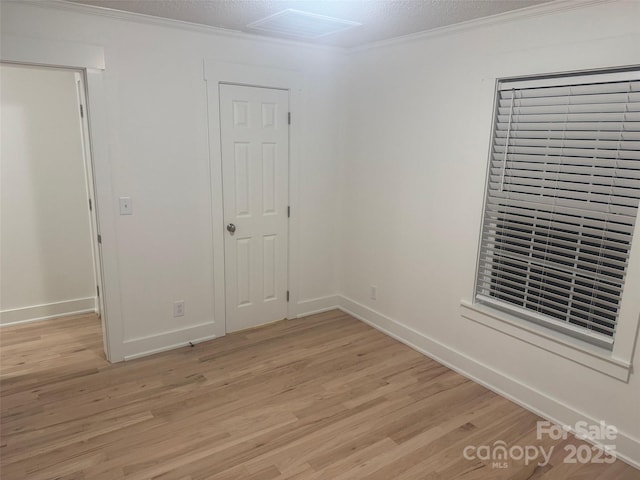 interior space with a textured ceiling, light hardwood / wood-style flooring, and crown molding