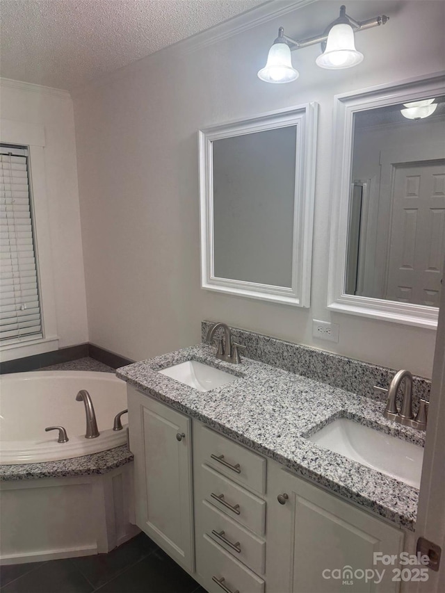 bathroom featuring tile patterned floors, vanity, a tub to relax in, and a textured ceiling