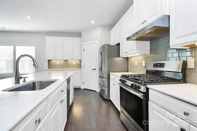 kitchen featuring light stone countertops, dark hardwood / wood-style flooring, stainless steel appliances, sink, and white cabinets