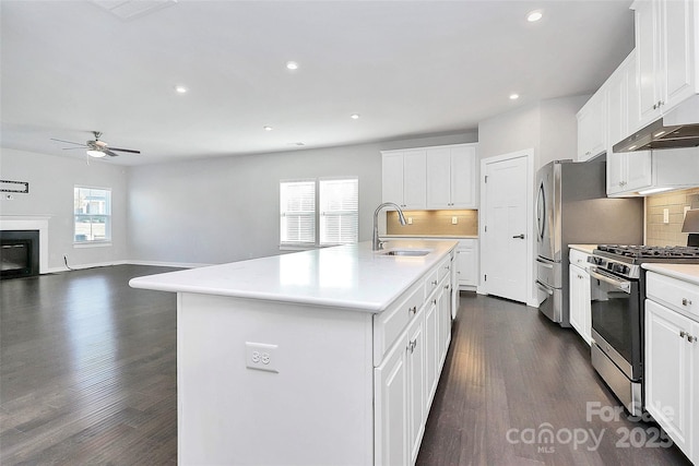 kitchen with white cabinetry, stainless steel range with gas cooktop, a center island with sink, and sink