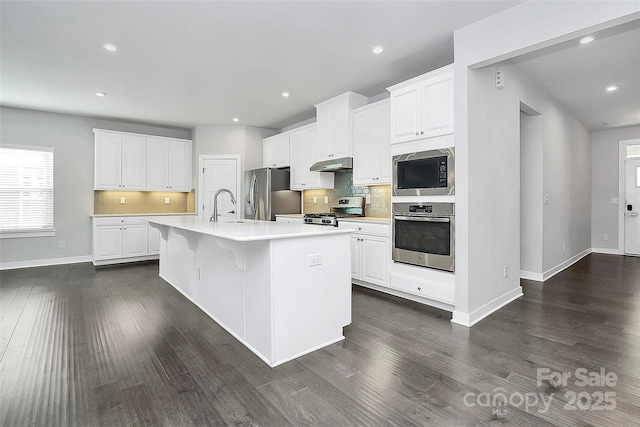 kitchen featuring a kitchen island with sink, sink, white cabinets, and appliances with stainless steel finishes