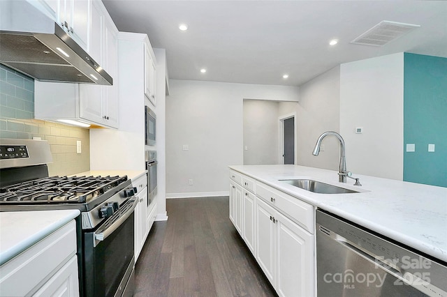 kitchen featuring backsplash, stainless steel appliances, sink, dark hardwood / wood-style floors, and white cabinetry