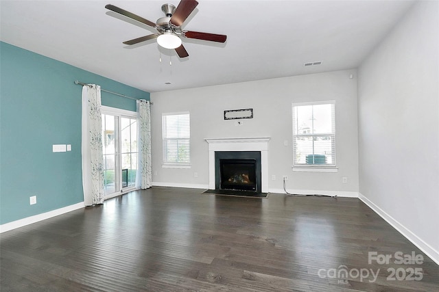 unfurnished living room featuring dark hardwood / wood-style floors, ceiling fan, and a healthy amount of sunlight