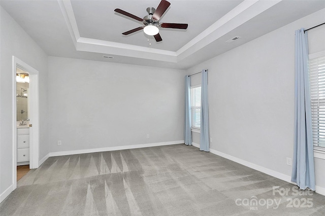 carpeted spare room featuring ceiling fan, a raised ceiling, and sink