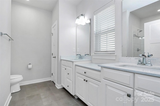 bathroom featuring a tile shower, vanity, toilet, and tile patterned floors