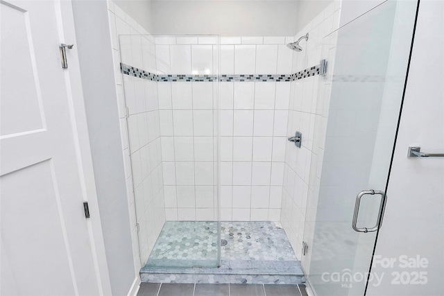 bathroom with tile patterned flooring and walk in shower