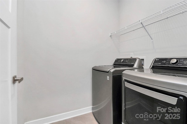 clothes washing area with light tile patterned floors and washer and dryer