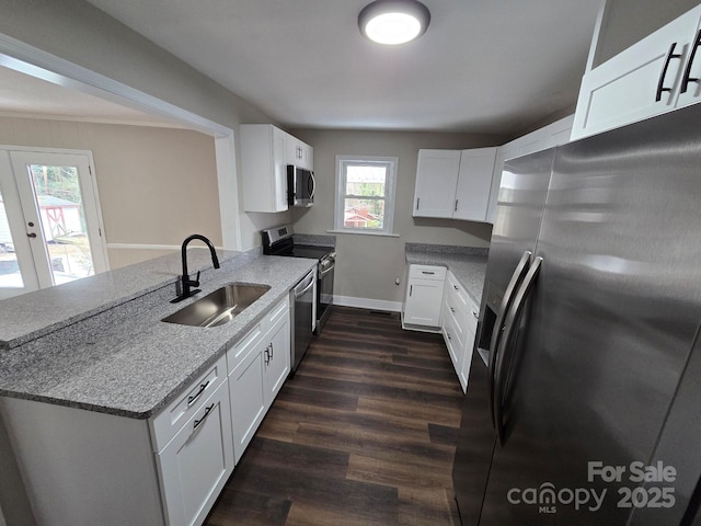 kitchen featuring white cabinetry, sink, stainless steel appliances, and kitchen peninsula