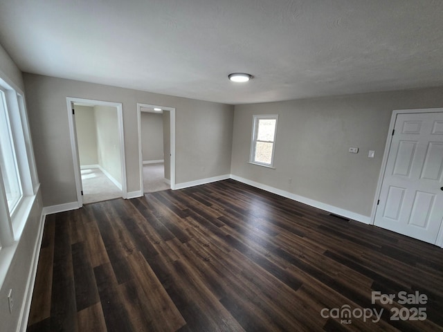 unfurnished bedroom featuring dark hardwood / wood-style flooring, a textured ceiling, and ensuite bathroom