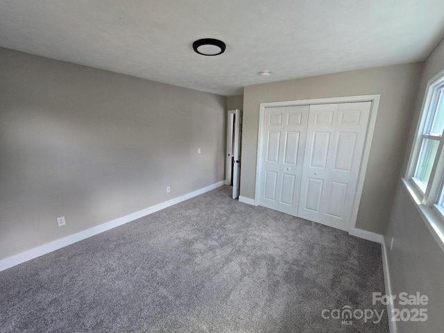 unfurnished bedroom with a closet and dark colored carpet