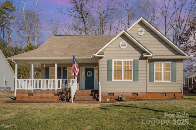 view of front facade with covered porch and a yard