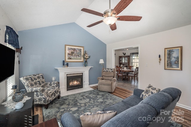 living room featuring ceiling fan, hardwood / wood-style floors, and vaulted ceiling