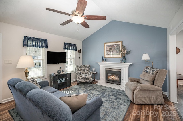 living room featuring lofted ceiling, ceiling fan, a premium fireplace, and hardwood / wood-style floors