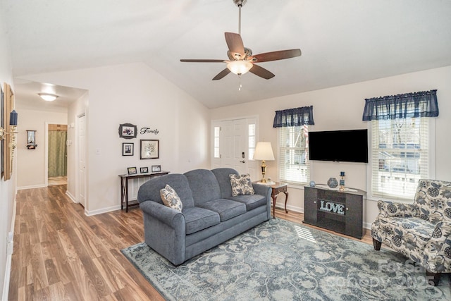 living room with ceiling fan, hardwood / wood-style flooring, and lofted ceiling